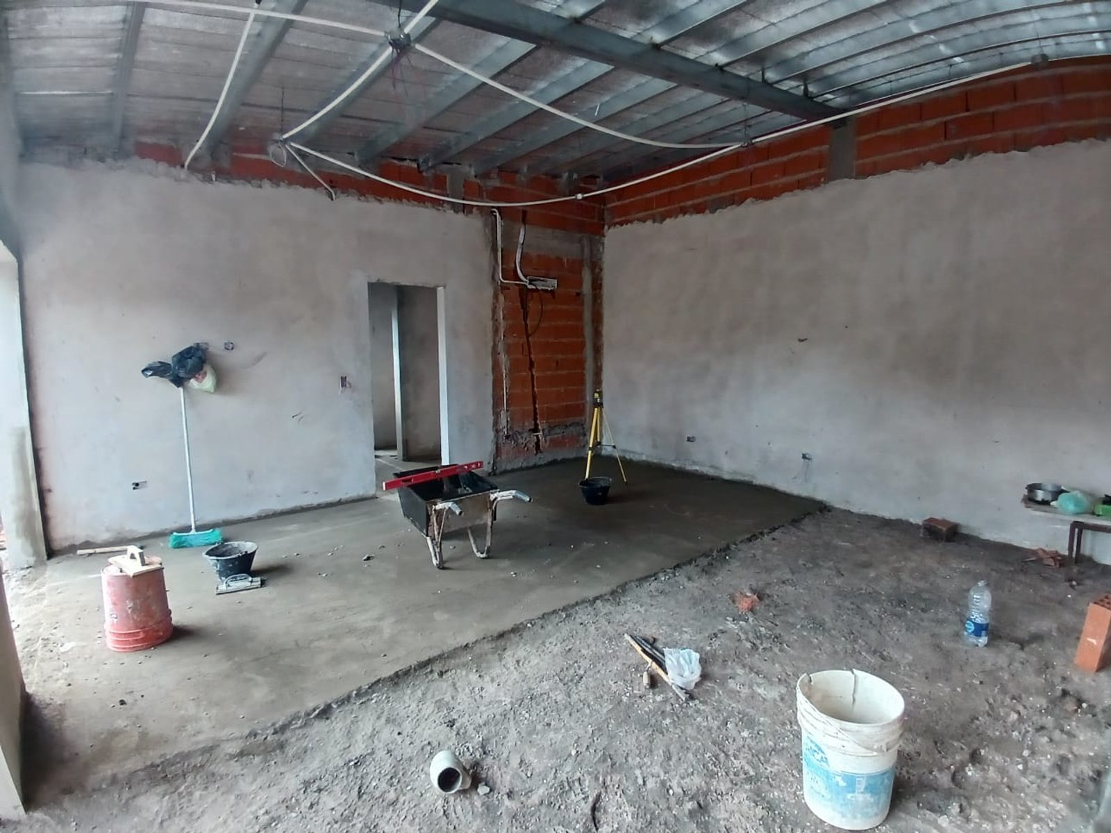 Espaço interno em construção com pisos e paredes de concreto e microcimento — projeto Quincho G+G, por Sep Arquitectura, em La Plata